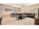 Spacious living room featuring carpet floors, a ceiling fan, and a comfortable brown sectional sofa at 7349 Merimack Oaks St, Las Vegas, NV 89166