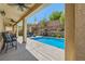 Inviting backyard pool with a covered patio, lounge chairs, and well-maintained landscaping at 7349 Merimack Oaks St, Las Vegas, NV 89166