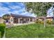 Spacious backyard with a covered patio, lush green lawn, and mature trees for privacy at 7432 Tahoe Basin Dr, Las Vegas, NV 89129