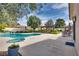 Expansive backyard featuring a pool, spa, patio, mature trees, and a pergola at 7432 Tahoe Basin Dr, Las Vegas, NV 89129