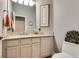 Bright bathroom with marble countertop, white cabinets, decorative wall art, and a floral arrangement on the toilet at 7432 Tahoe Basin Dr, Las Vegas, NV 89129