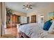 Comfortable bedroom featuring a king-sized bed, hardwood floors, a large decorative armoire, and neutral walls at 7432 Tahoe Basin Dr, Las Vegas, NV 89129