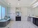 A luxurious bathroom with a soaking tub, glass shower, and marble-style tile throughout at 7695 Windy Meadow Ave, Las Vegas, NV 89178