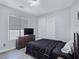 Modern bedroom featuring wood floors, a comfortable bed, dresser with a TV, and a closet for storage at 7695 Windy Meadow Ave, Las Vegas, NV 89178