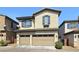 Two story home featuring a two car garage and desert landscaping at 7695 Windy Meadow Ave, Las Vegas, NV 89178