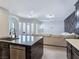 A view of the kitchen featuring a black countertop island, stainless steel appliances, and a glimpse into the living room at 7695 Windy Meadow Ave, Las Vegas, NV 89178
