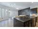 Modern kitchen with island, black countertops, stainless steel appliances, and an open view of the living area at 7695 Windy Meadow Ave, Las Vegas, NV 89178