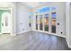 Spacious living room featuring wood-look floors, large windows, and direct access to the outdoors at 7695 Windy Meadow Ave, Las Vegas, NV 89178