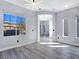 Spacious living room with abundant natural light, complemented by modern gray flooring at 7695 Windy Meadow Ave, Las Vegas, NV 89178