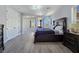 Large main bedroom featuring wood floors and access to a sitting room with a balcony and modern furnishings at 7695 Windy Meadow Ave, Las Vegas, NV 89178