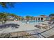 Community pool and spa surrounded by lounge chairs and outdoor seating area at 7695 Windy Meadow Ave, Las Vegas, NV 89178