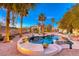 Backyard with a custom pool, lush desert landscaping, and mountain views at 784 Tossa De Mar Ave, Henderson, NV 89002
