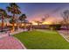 Beautiful backyard with putting green, manicured landscaping, and a sunset view at 784 Tossa De Mar Ave, Henderson, NV 89002