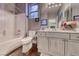 Full bathroom showcasing a shower-tub combo with a unique stained-glass window and rustic wood-look vanity at 784 Tossa De Mar Ave, Henderson, NV 89002