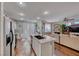 Open kitchen boasts an island with seating, stainless steel appliances and transitions to the living room at 784 Tossa De Mar Ave, Henderson, NV 89002