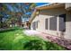 The backyard has a grassy lawn, mature trees and covered patio at 7913 Sailboat Ln, Las Vegas, NV 89145