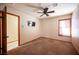 This bedroom features neutral walls and carpet, window with blinds, and a ceiling fan with light at 7913 Sailboat Ln, Las Vegas, NV 89145