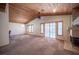 Bright living room with a fireplace, wood ceilings, and sliding doors to the backyard at 7913 Sailboat Ln, Las Vegas, NV 89145