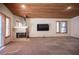 Spacious living room featuring a fireplace, wood ceiling, and large window at 7913 Sailboat Ln, Las Vegas, NV 89145