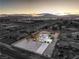 Expansive aerial view of a modern desert home showcasing the large lot and mountain views at sunset at 8645 Edmond St, Las Vegas, NV 89139