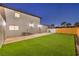 A fenced-in backyard features a patch of artificial turf, perfect for a low-maintenance outdoor space at 8645 Edmond St, Las Vegas, NV 89139