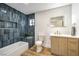 Stylish bathroom with a blue tiled shower and a modern vanity with gold fixtures and a lighted mirror at 8645 Edmond St, Las Vegas, NV 89139