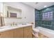 Modern bathroom with light wood vanity, quartz countertop, and a blue tiled shower-tub combo at 8645 Edmond St, Las Vegas, NV 89139