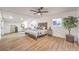 Spacious bedroom with wood floors, a ceiling fan, and a comfortable seating area by the windows at 8645 Edmond St, Las Vegas, NV 89139