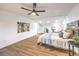 Bright bedroom with hard wood floors, ceiling fan, recessed lighting, artwork, and a seating area at 8645 Edmond St, Las Vegas, NV 89139