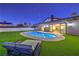 Spacious pool area with artificial grass, tanning chair, and home in background at 8645 Edmond St, Las Vegas, NV 89139
