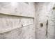 Modern shower featuring marble-style tile, gold fixtures and built-in shelving at 8645 Edmond St, Las Vegas, NV 89139