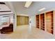 Bonus room with tile floors, wood accent wall, wood shelves and connected to the living room at 9010 W Lone Mountain Rd, Las Vegas, NV 89129