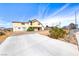 Two-story home with a long concrete driveway, desert landscaping, and a blue sky background at 9010 W Lone Mountain Rd, Las Vegas, NV 89129