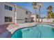 Backyard featuring a pool, palm trees, and the house's back facade creating a perfect outdoor entertainment space at 9776 Whitewater Canyon Ct, Las Vegas, NV 89183