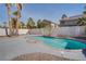 Backyard pool featuring a pebble base, palm trees, and privacy wall, creating a relaxing outdoor oasis at 9776 Whitewater Canyon Ct, Las Vegas, NV 89183