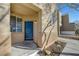 Welcoming front entrance featuring a blue door, covered porch, and low-maintenance landscaping at 7506 Village Mist Ln, Las Vegas, NV 89113