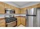 Modern kitchen featuring stainless steel appliances, including a gas range and refrigerator, and wood cabinets at 7506 Village Mist Ln, Las Vegas, NV 89113