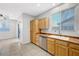 Kitchen area with wooden cabinets, stainless steel dishwasher, sink and a view of the sliding glass door at 7506 Village Mist Ln, Las Vegas, NV 89113