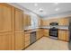 Well-lit kitchen with stainless steel appliances, wooden cabinets, tile floors, and ample counter space at 7506 Village Mist Ln, Las Vegas, NV 89113