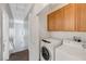 Convenient laundry room with washer, dryer, and upper cabinet storage at 7506 Village Mist Ln, Las Vegas, NV 89113