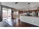 Open-concept kitchen with dark wood cabinets, granite countertops, stainless steel appliances, and access to the patio at 8307 Amtrak Express, Las Vegas, NV 89131