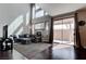 Bright living room with high ceilings, a fireplace, a comfortable sofa, and sliding glass doors to the outdoor patio at 8307 Amtrak Express, Las Vegas, NV 89131