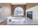 Bathroom with jacuzzi tub featuring decorative glass window, marble countertops, and a fireplace at 10024 Skipper Ct, Las Vegas, NV 89117