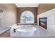 Bathroom with jacuzzi tub featuring decorative glass window, marble countertops, and a fireplace at 10024 Skipper Ct, Las Vegas, NV 89117