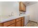 Laundry room featuring wood cabinets, a sink, white countertops, and a modern washer and dryer set at 10024 Skipper Ct, Las Vegas, NV 89117
