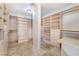 Walk-in Closet with custom built-in shelving and drawers, and neutral tile flooring at 10024 Skipper Ct, Las Vegas, NV 89117