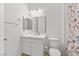Bright bathroom features a white vanity, framed mirror, and a floral shower curtain at 10196 Millholm Ave, Las Vegas, NV 89166