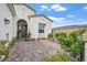 Inviting front courtyard with lush greenery, a brick-paved patio and comfortable seating at 10196 Millholm Ave, Las Vegas, NV 89166