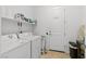 Functional laundry room with washer, dryer, storage shelves, and utility sink at 10196 Millholm Ave, Las Vegas, NV 89166