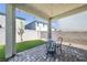 View of the covered patio with a brick base and synthetic grass at 10214 Natural Anchor St, Las Vegas, NV 89166